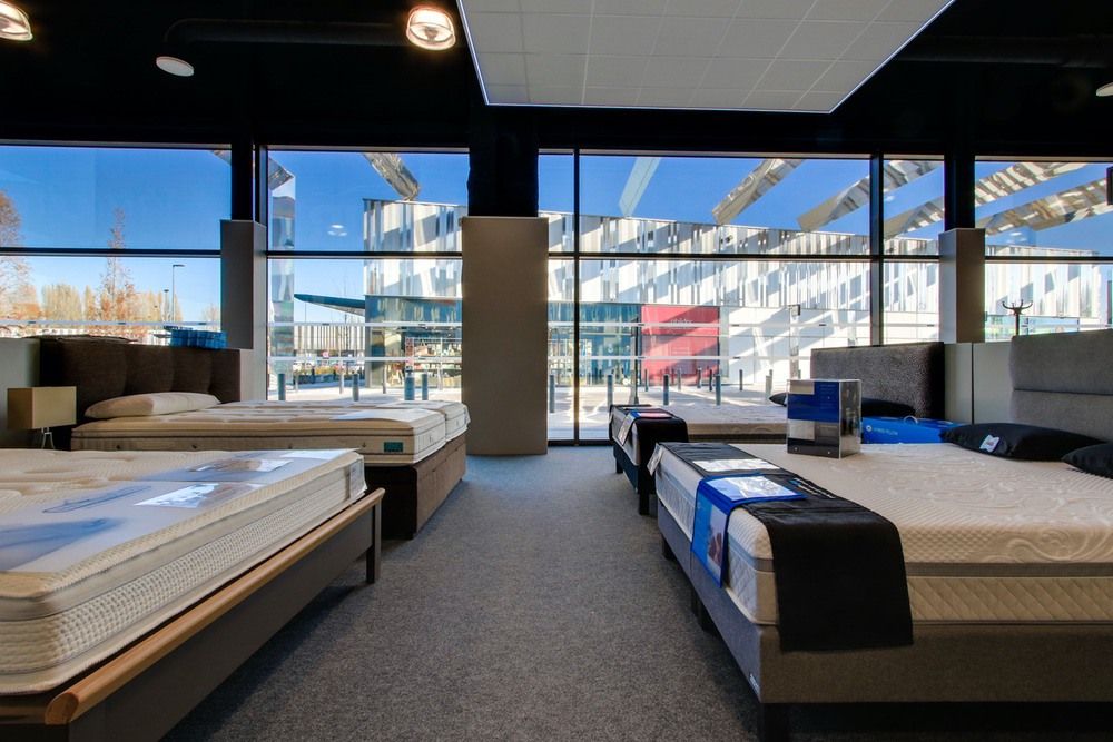 Photo de la vitrine intérieure du magasin vitaliterie présentant plusieurs matelas pour illustrer les mentions légales